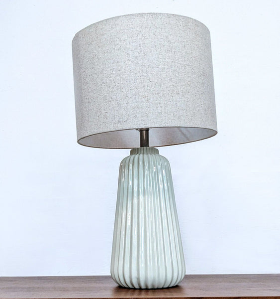 Ceramic table lamp with a textured base and fabric shade, by Reperch.