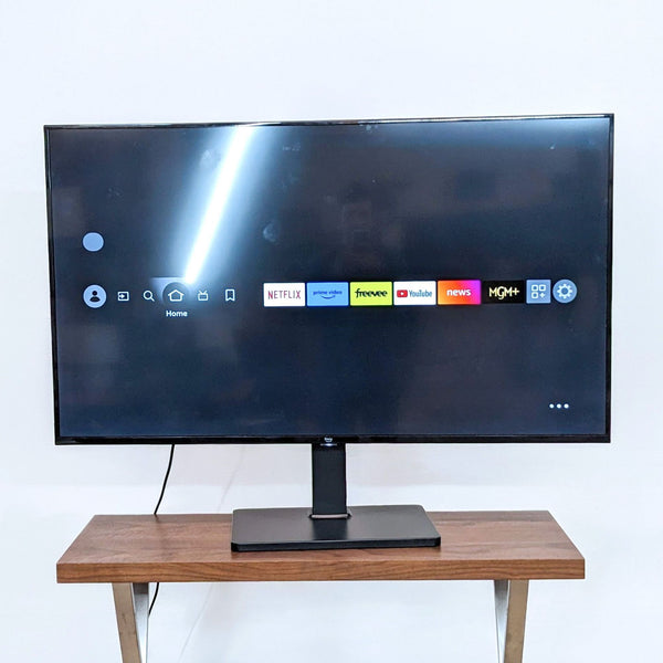 Front view of Amazon 55" Fire TV showing streaming apps on a wooden stand.