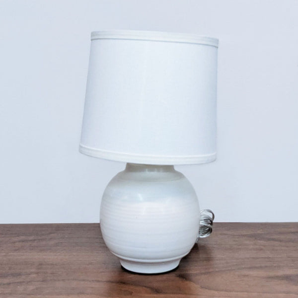 Small white Reperch table lamp with matching shade on a wooden surface.