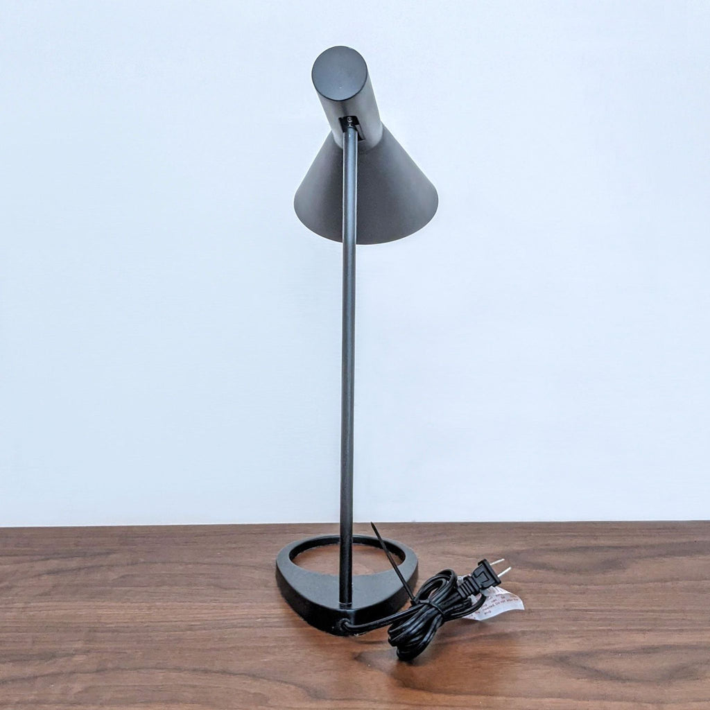 Stylish black table lamp with a geometric design on a wooden table.