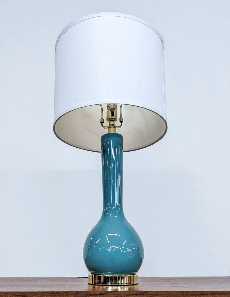 Top view of teal lamp showing bulb and gold hardware.