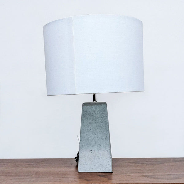 Modern Reperch lamp with a rectangular concrete base and a white cylindrical shade.