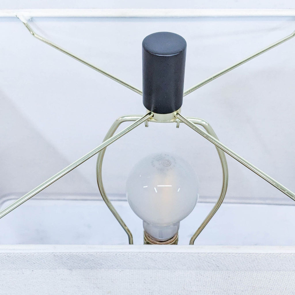 Interior view of the lamp revealing its bulb and wiring.