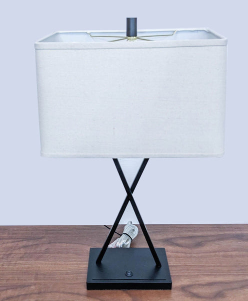 Modern table lamp with rectangular shade on a wooden surface.