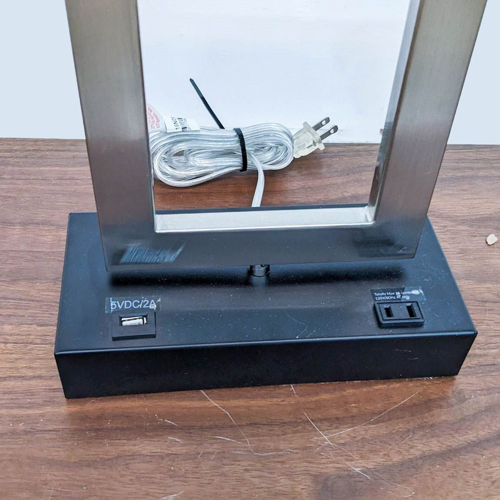 Lamp base with USB and power outlets on a wooden table.