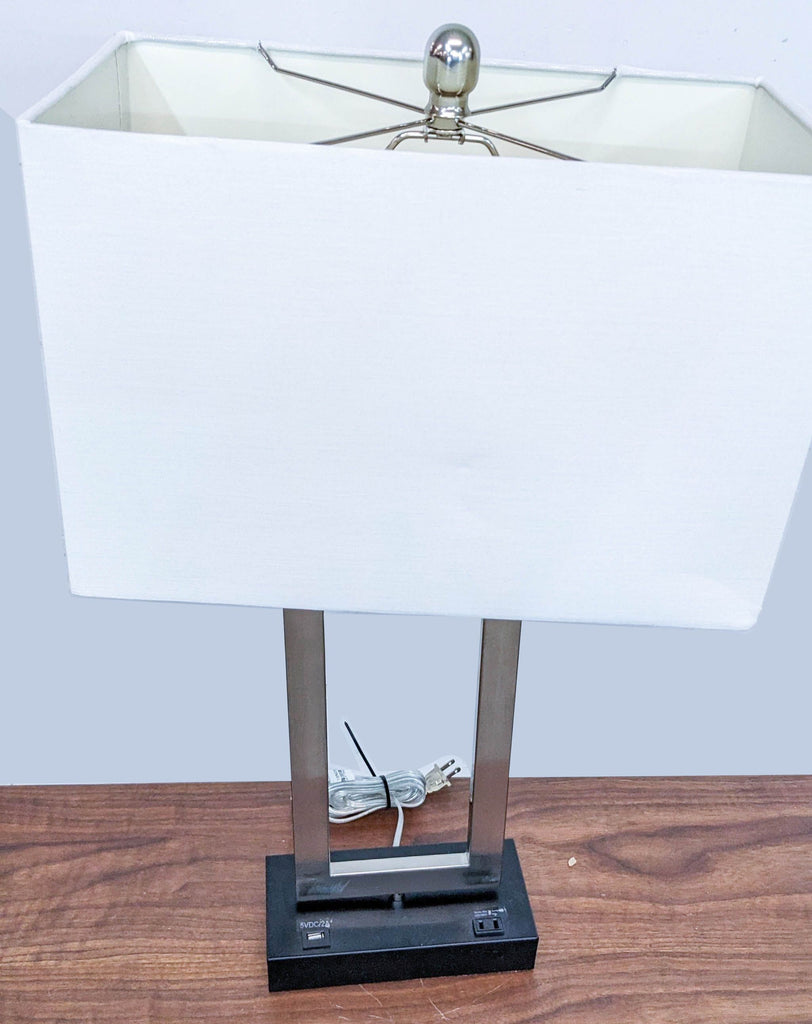 White rectangular lampshade with metal supports by Reperch on a table.