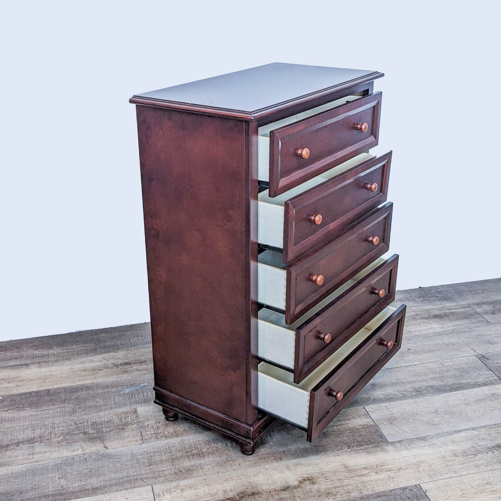 Side view of the Palisades dresser by Europa Baby, showcasing open drawers on wood floor.