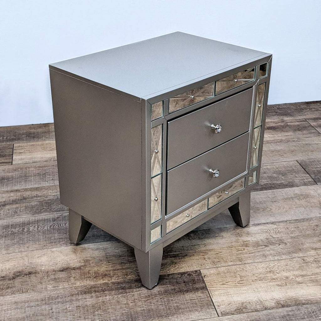 Retro metallic nightstand with etched mirrors, tapered legs, and dual drawers.