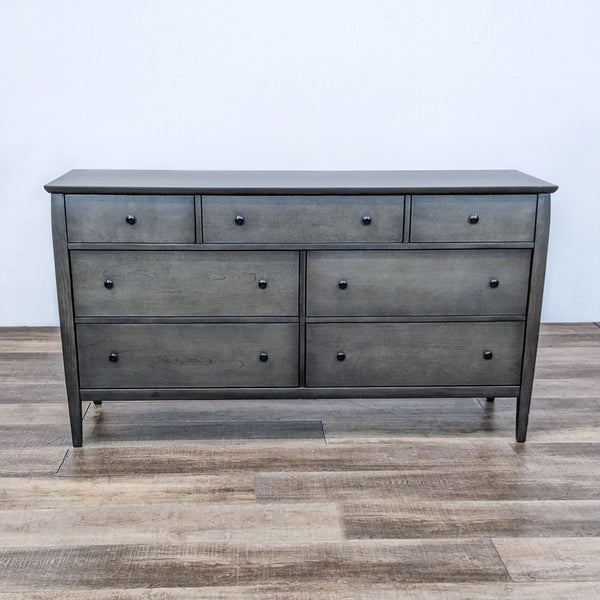 Front view of a smoky grey-brown 7-drawer dresser on wooden floor.