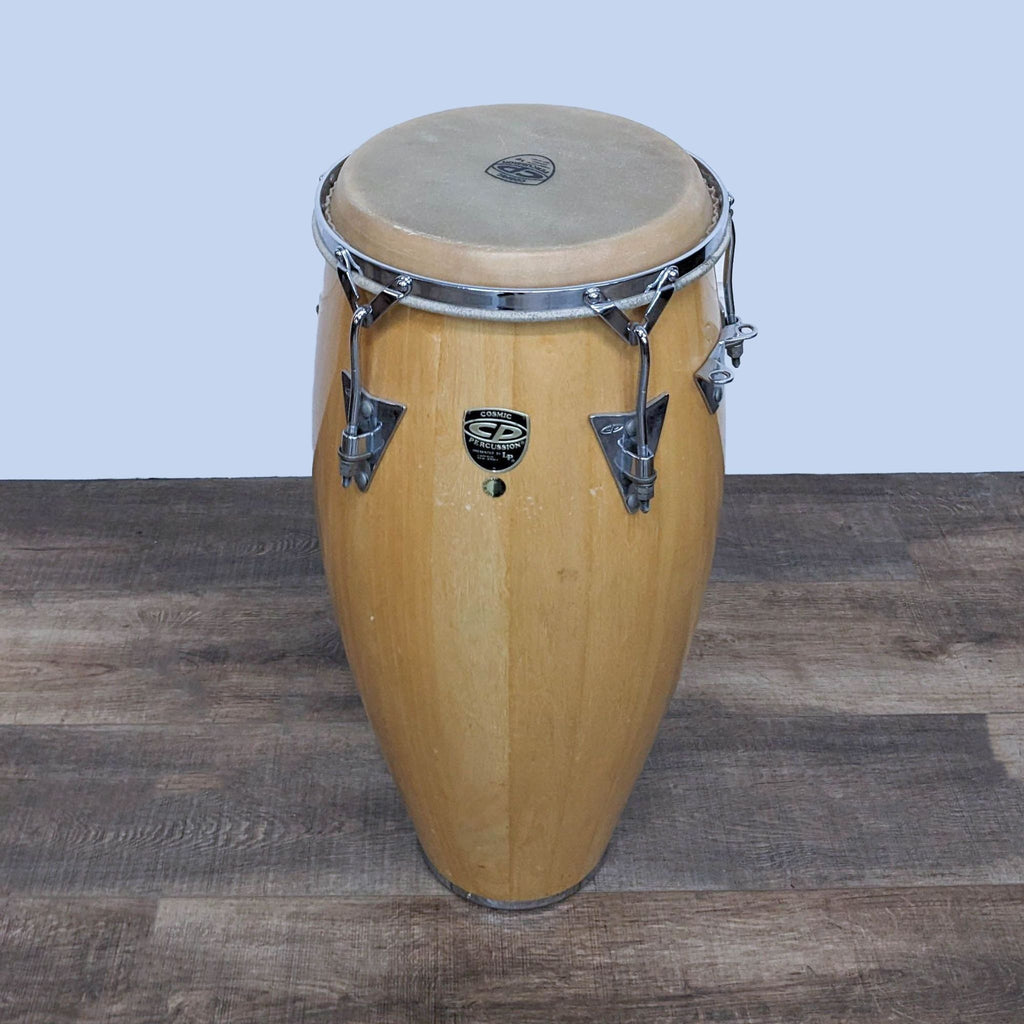 Pair of wooden conga drums with natural skin heads and chrome hardware.
