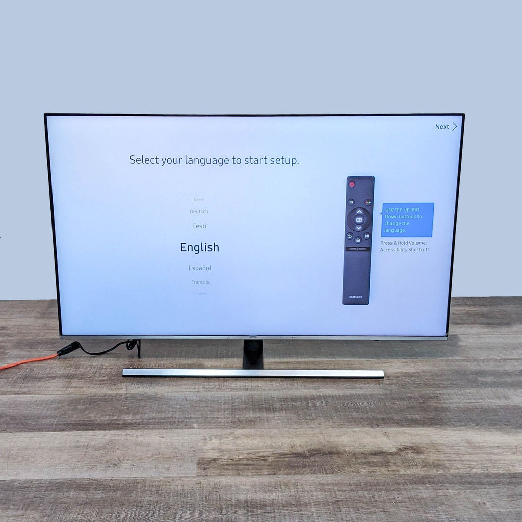 Samsung TV setup screen showing language selection options with a remote control guide.