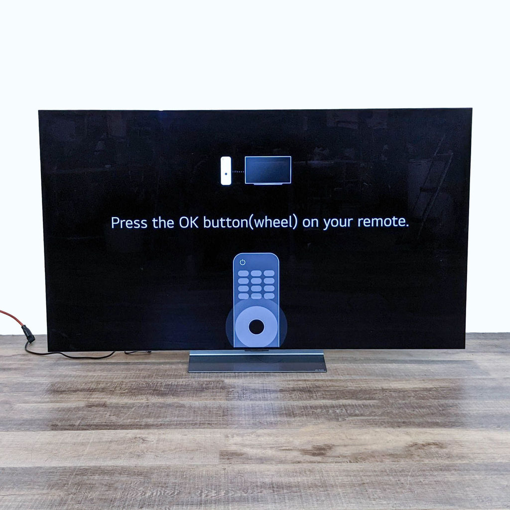 Ultra-slim LG OLED evo C3 TV showing a remote setup instruction.