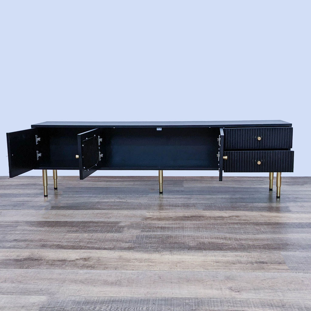 Open view of entertainment center, showcasing interior storage space and gold metal legs.
