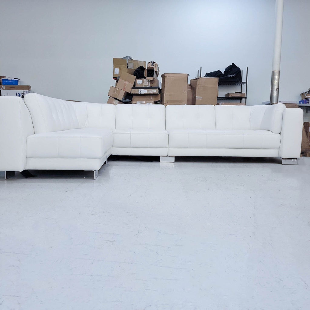 3. Front view of Reperch brand 135" white leather sectional with curve back and sleek chrome feet.