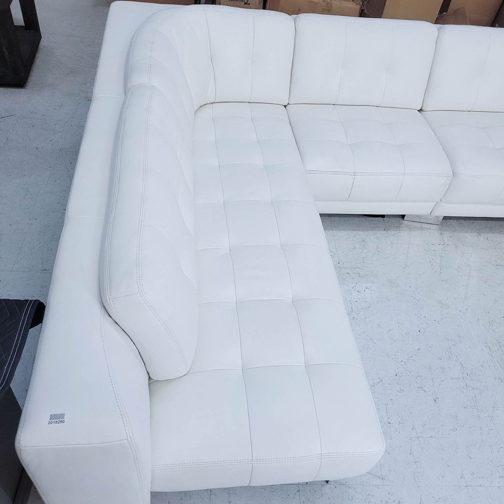 1. Overhead view of a tufted white leather sectional with a curved back and chrome feet, by Reperch.