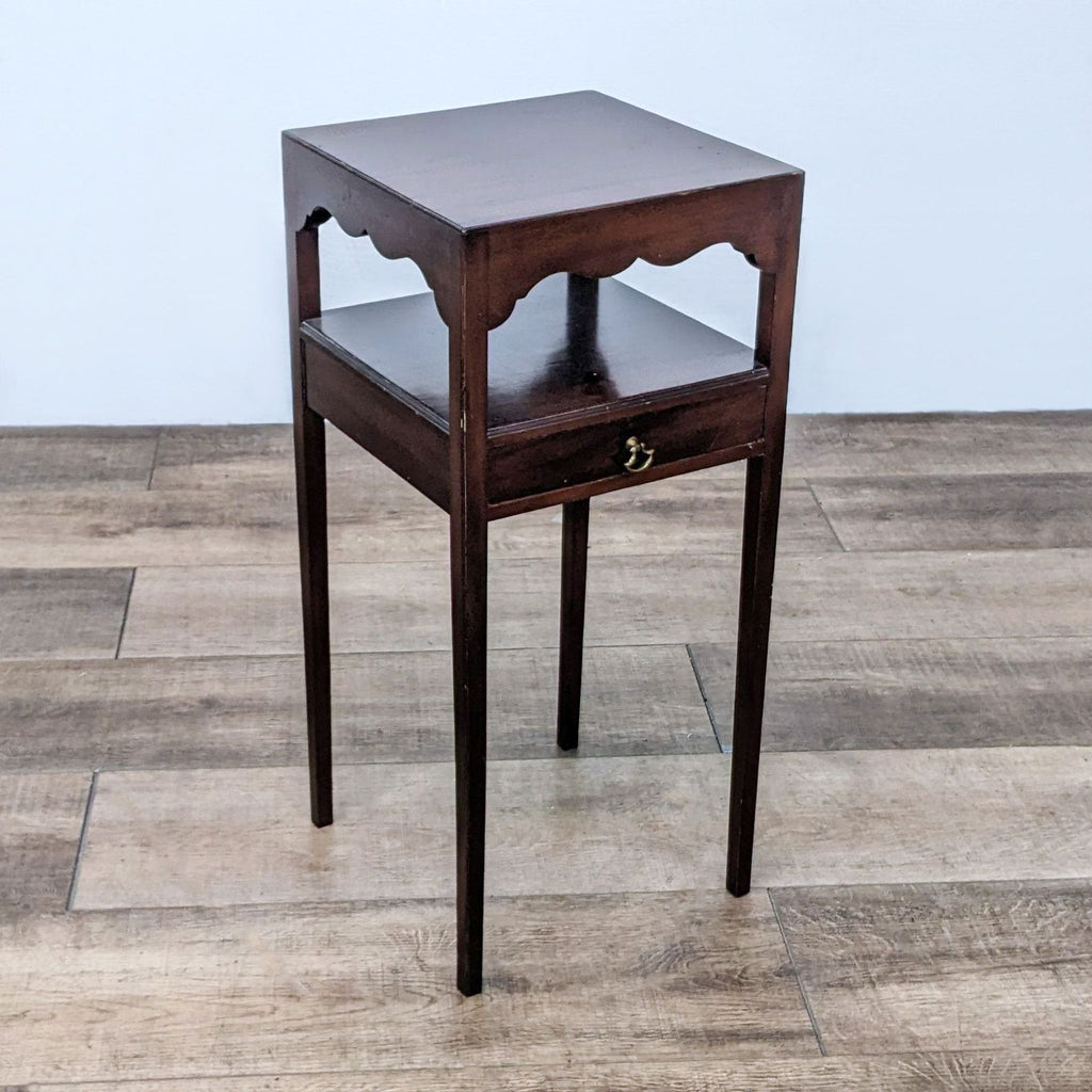 Elegant side table showcasing scalloped edges and open drawer.