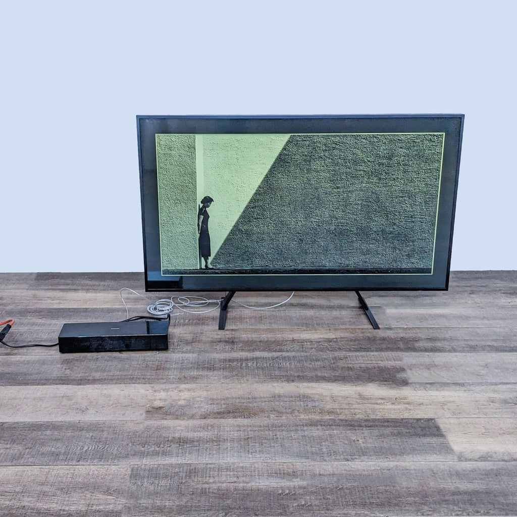 Samsung TV showing an image of a person in shadows, with connected cables.
