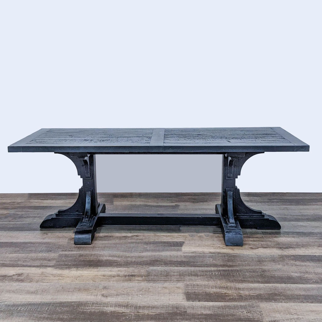 Restoration Hardware reclaimed wood dining table with plank top and double pedestal trestle base, on wood floor.