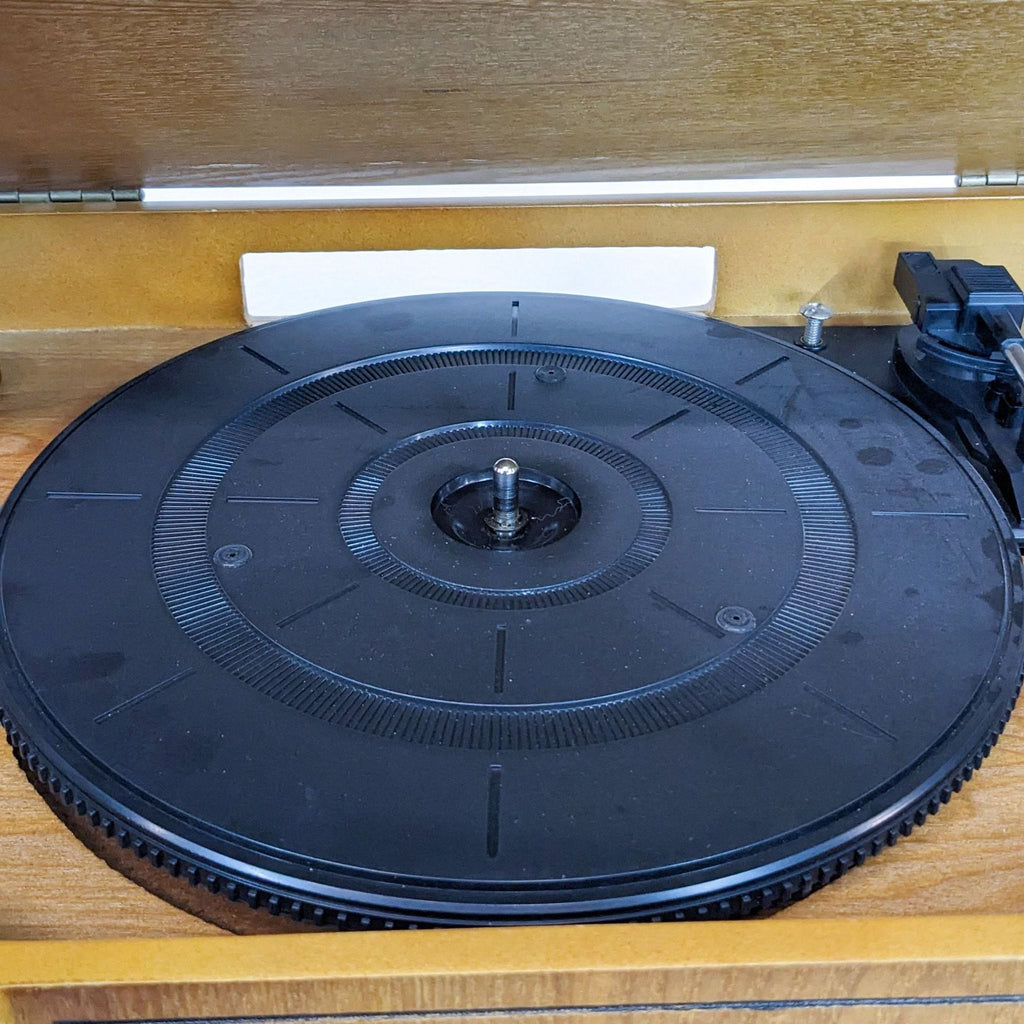 Close-up of the turntable inside a wooden music center, highlighting its classic design.
