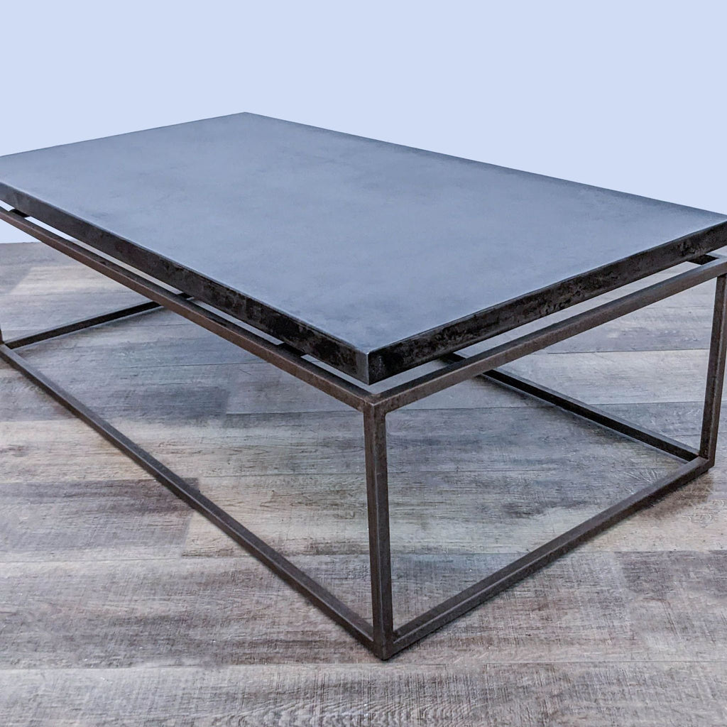 Reperch coffee table with metal frame and elevated metal top on wooden floor.