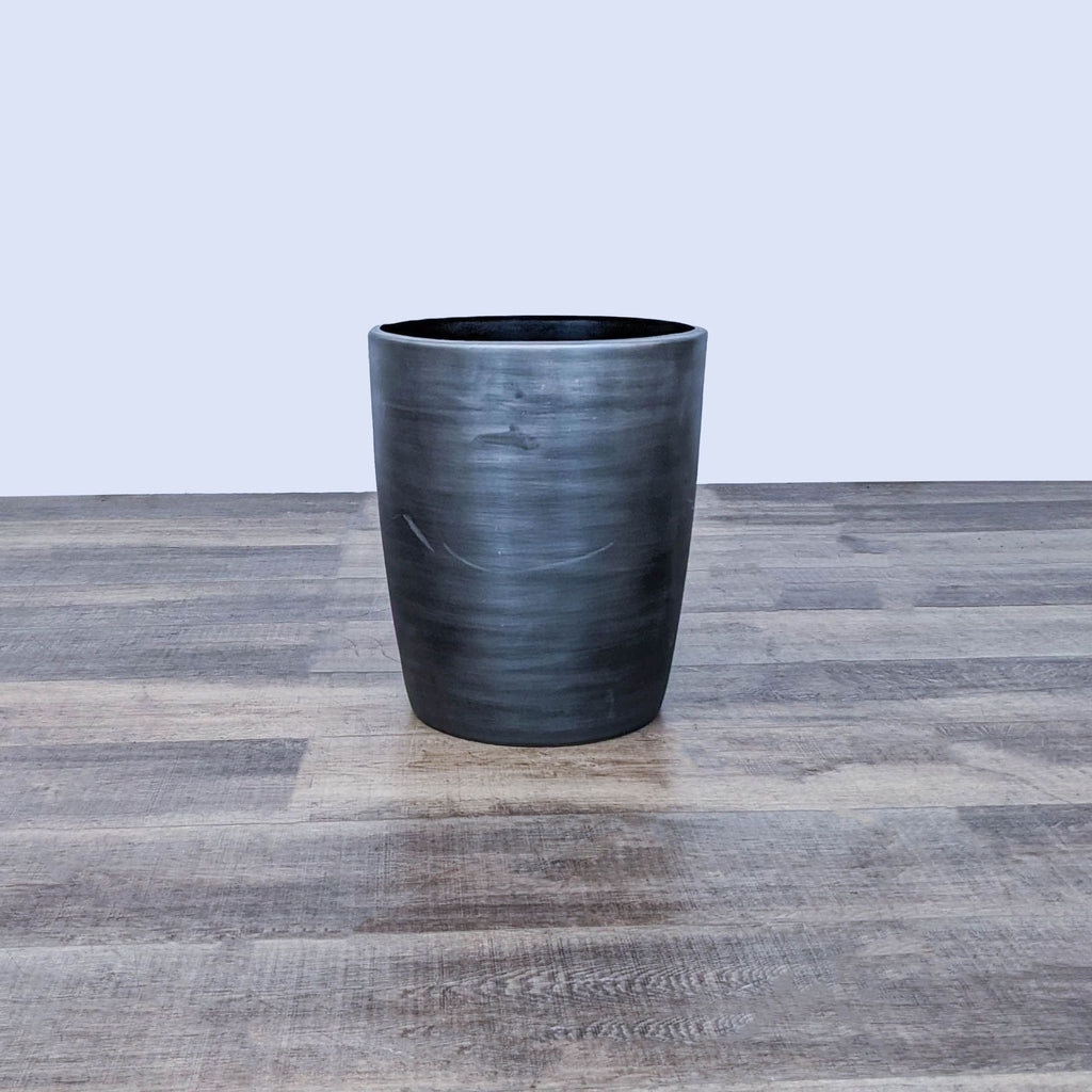 Reperch drum table on a wooden floor, showcasing sleek design.