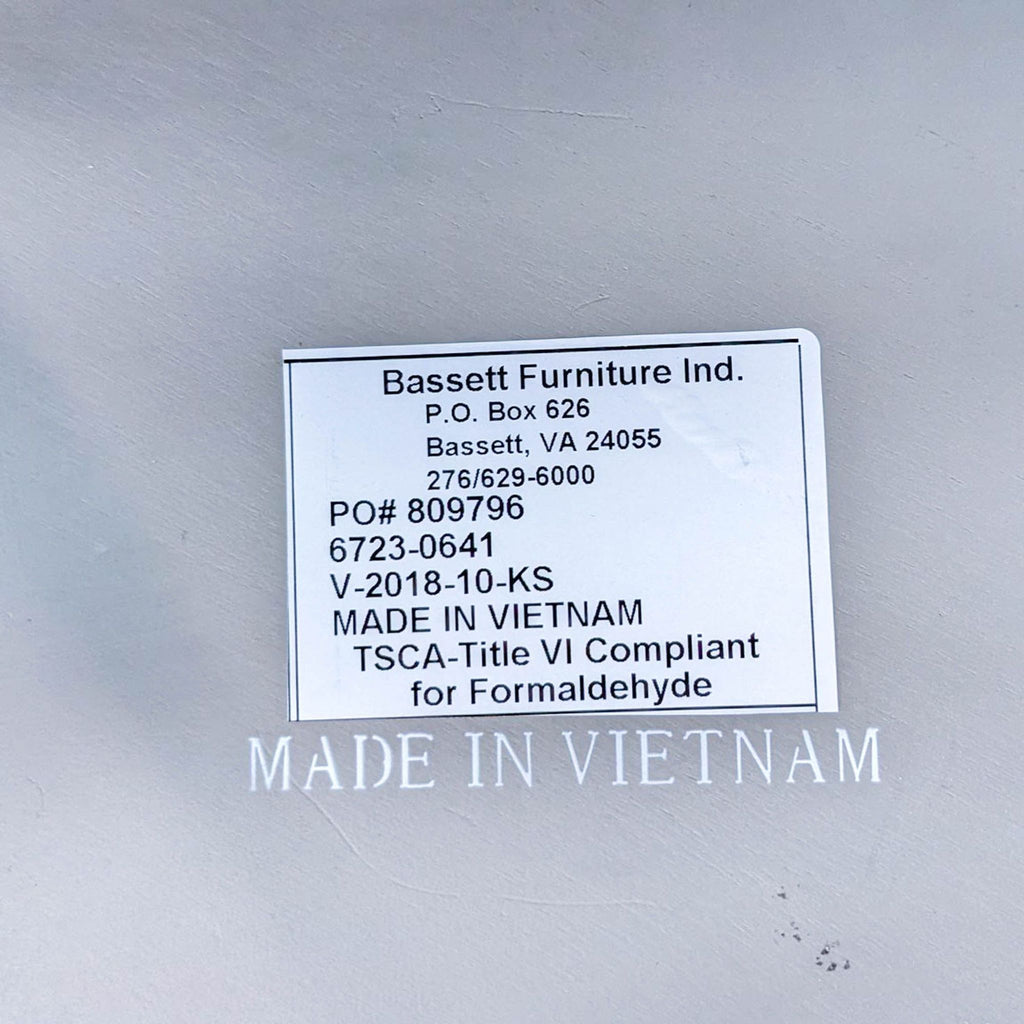 Label of Bassett Furniture on a side table, indicating it's made in Vietnam, with compliance details.