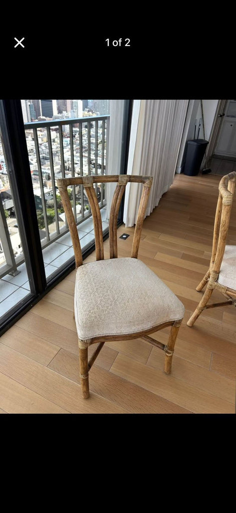 1. McGuire dining chair with curved rattan frame and light cushioned seat, ideal for elegant dining settings.  