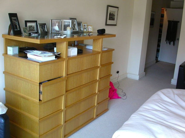 Wooden dresser with 15 drawers and a top display shelf, ideal for bedroom storage and decor.