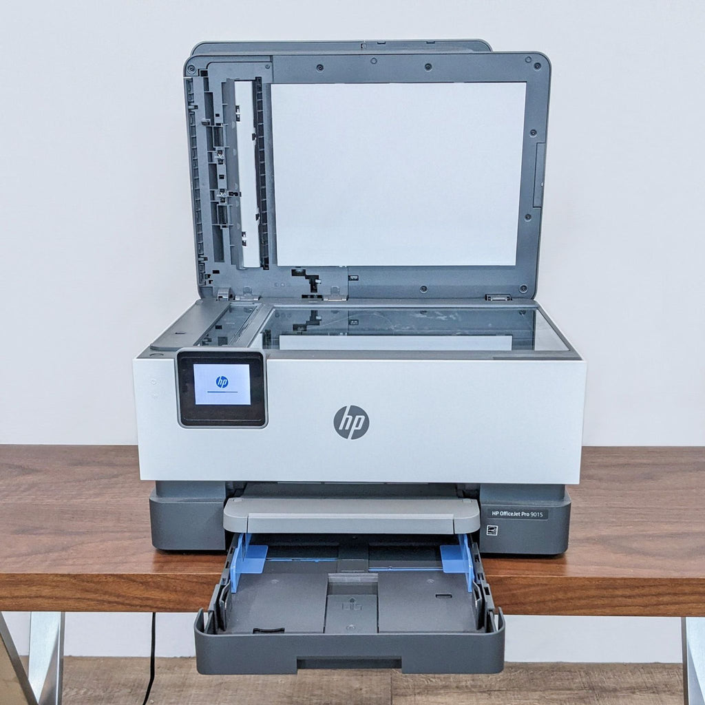 HP all-in-one printer on a desk with the scanning lid open and paper tray extended, ideal for a home office.