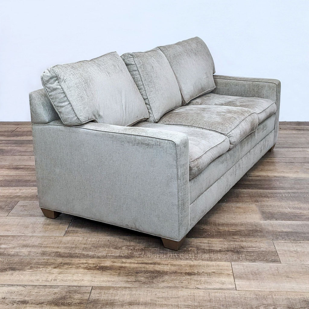 3-seat cushioned sofa with a modern silhouette, showcasing plush back pillows and wooden feet by Ethan Allen.