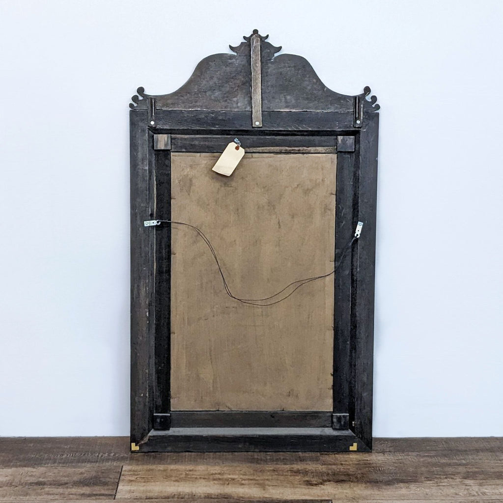 Back view of vintage Queen Ann mirror with a simple wood backing. Decorative top detail visible. Brand: Reperch.