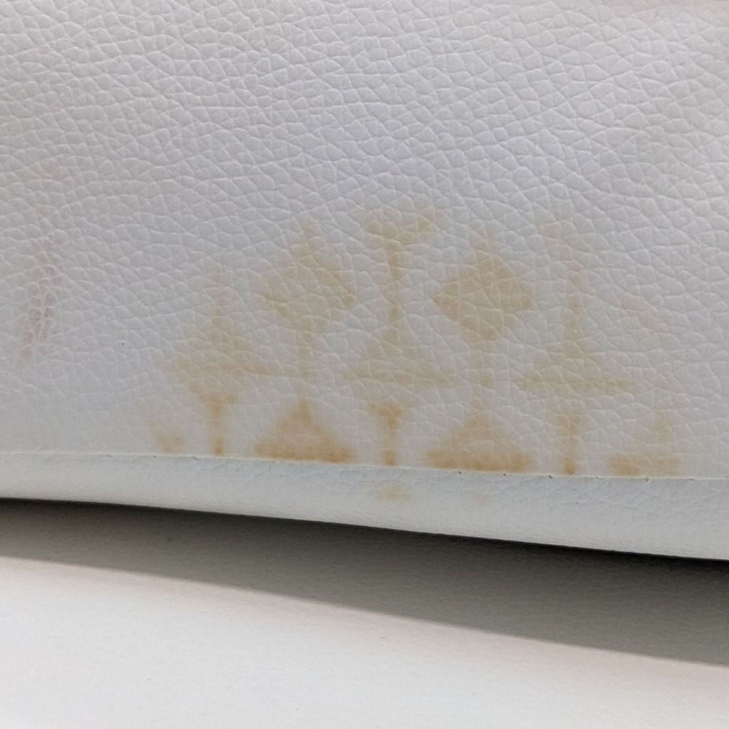 Close-up of a white Reperch sleeper sofa showing stains on the surface.