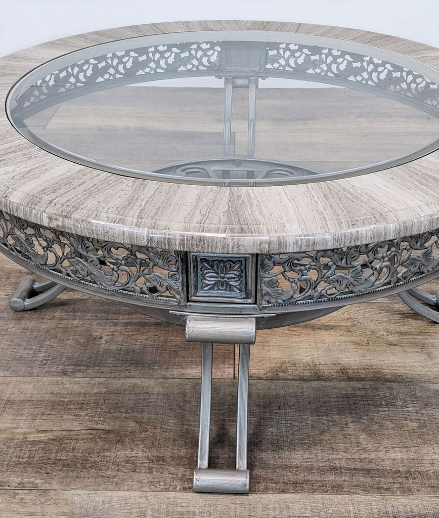 Reperch brand coffee table with a decorative metal base, apron, and circular glass top.