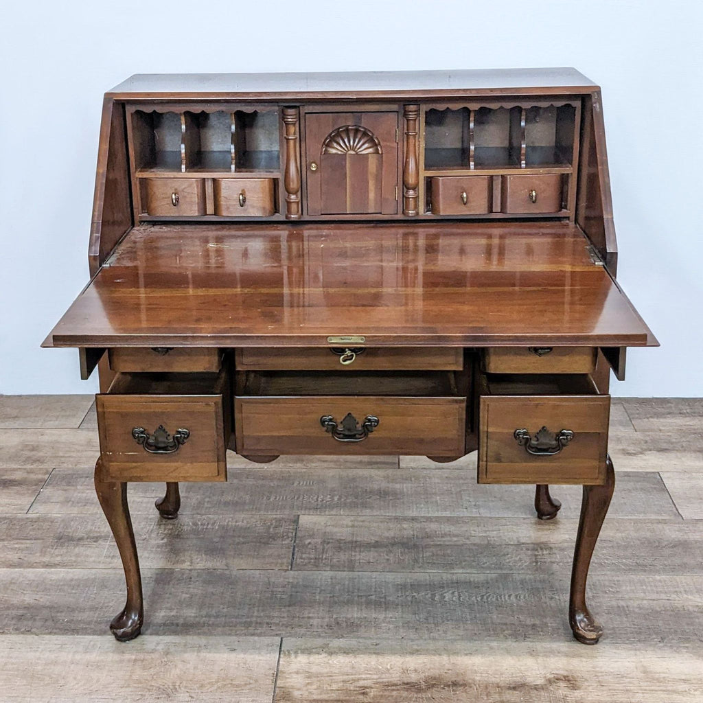 Compact desk with drop-front, six drawers, and shelves for ample storage.