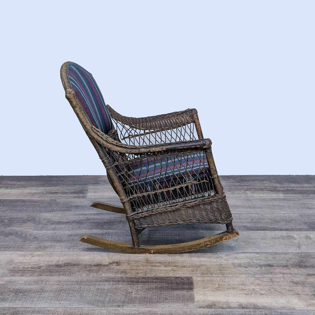 Top-down view of a Reperch rattan rocking chair with plush striped cushions on a wooden surface, highlighting the chair's contours.