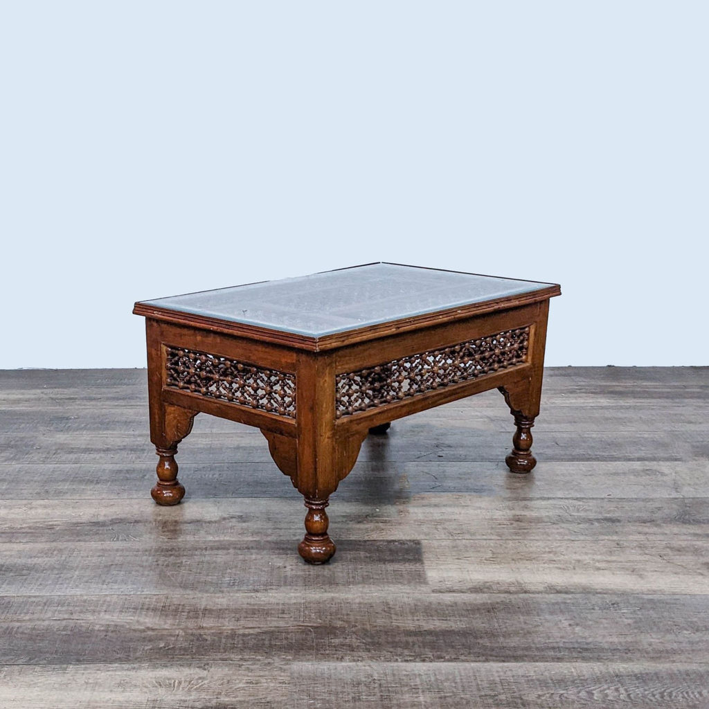 2. Frontal view of a wooden Reperch coffee table with carved mashrabiya design and mother-of-pearl details, on a wood-patterned floor.