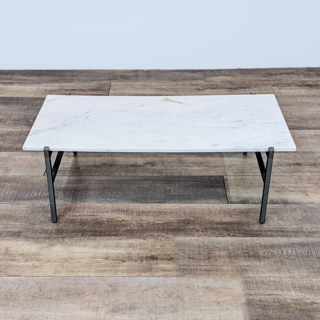 Rectangular marble coffee table with sleek steel frame.