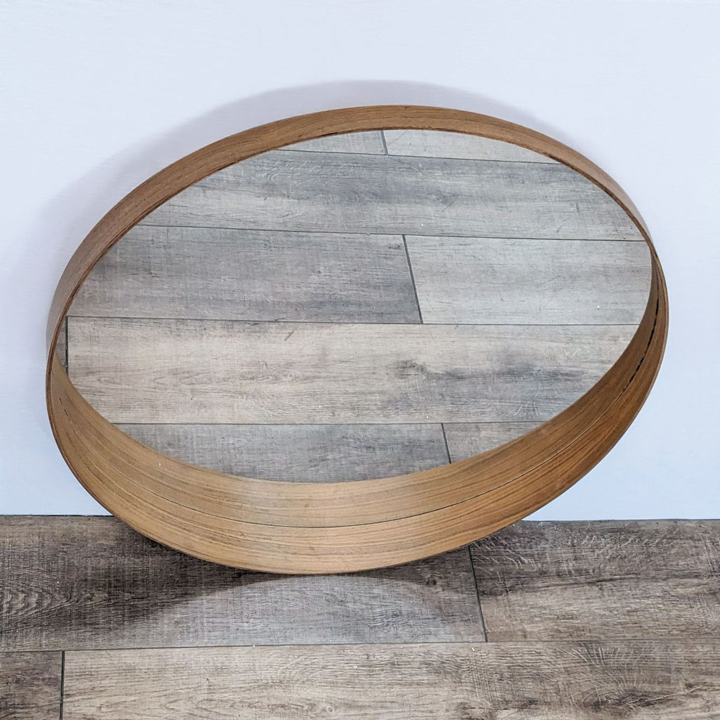Round mirror with brass metal frame from IKEA Stockholm, showcasing detailed wood reflection.