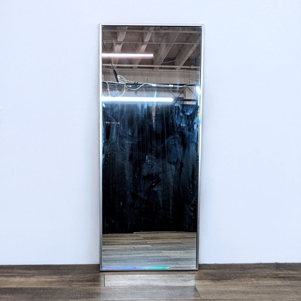 1. West Elm full length mirror with a brushed nickel metal frame, leaning against a white wall on wood flooring.