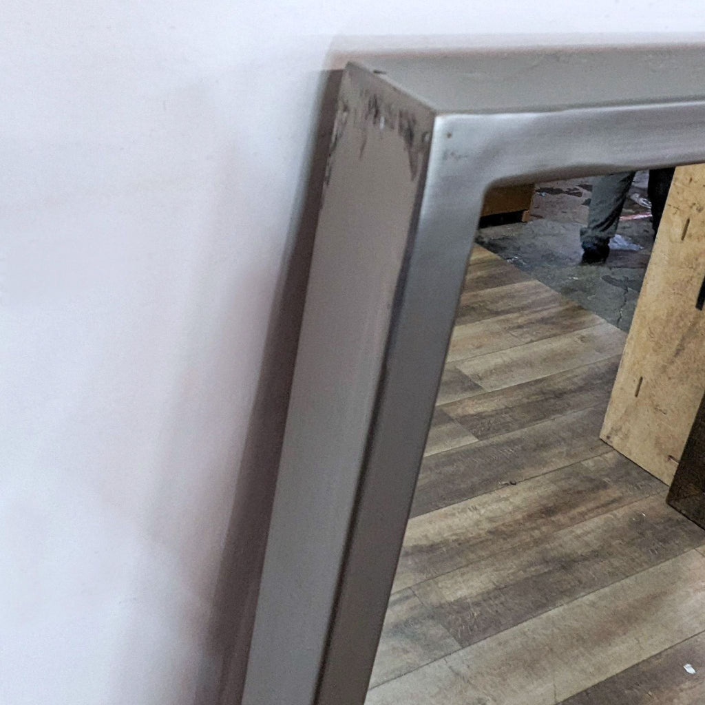 2. Close-up of the brushed nickel metal frame on the corner of the West Elm full length mirror.