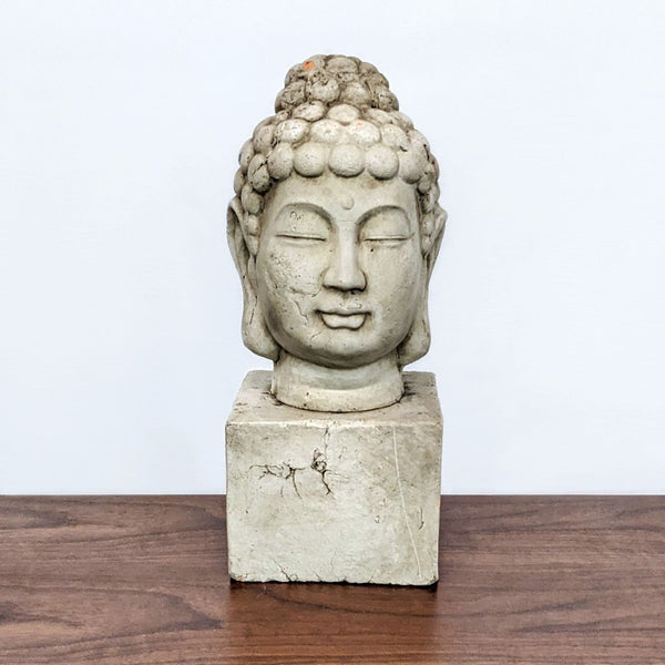 Terra cotta Buddha sculpture with aged finish, front view, on wooden surface.
