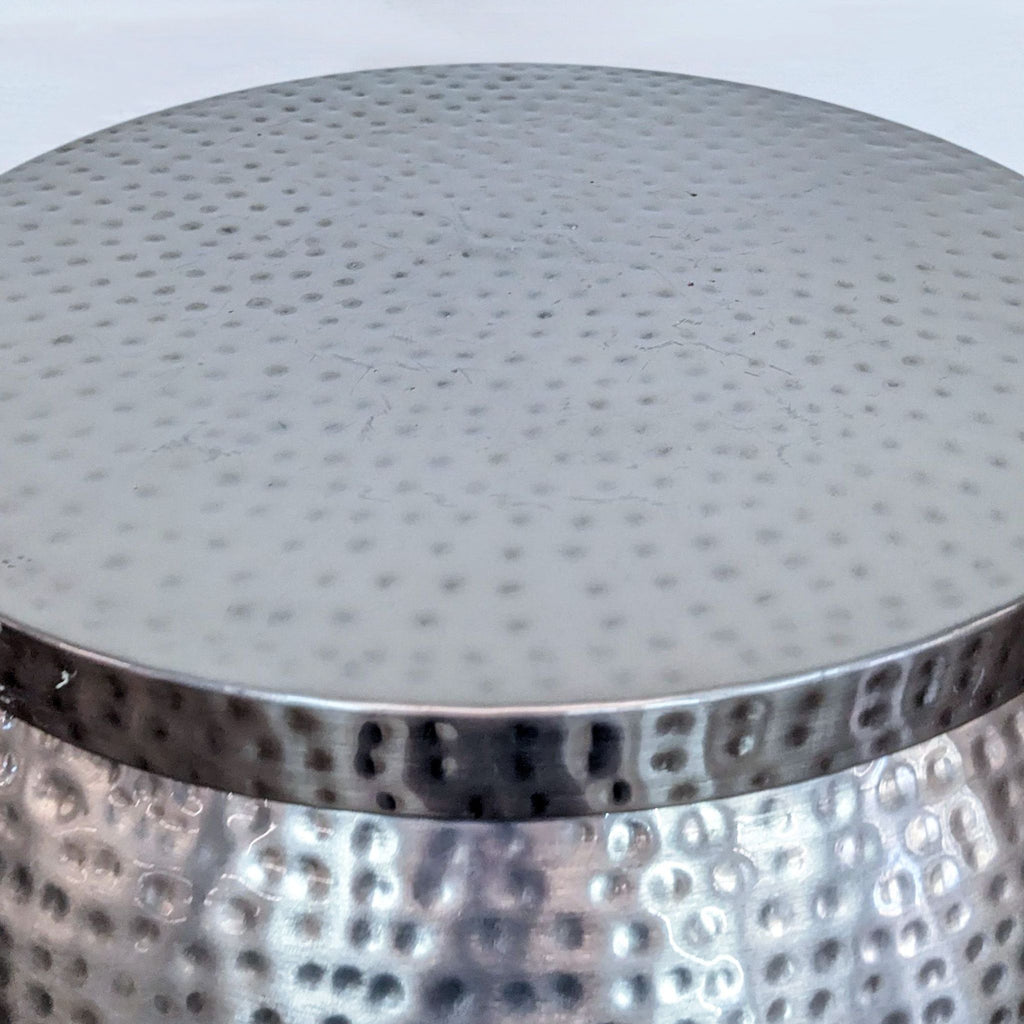 Silver accent table with a textured design, featuring a removable lid for hidden interior storage.