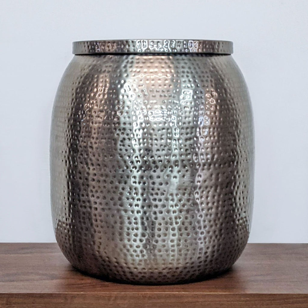 Hand-hammered steel table with a lustrous antiqued nickel finish and removable lid for storage.