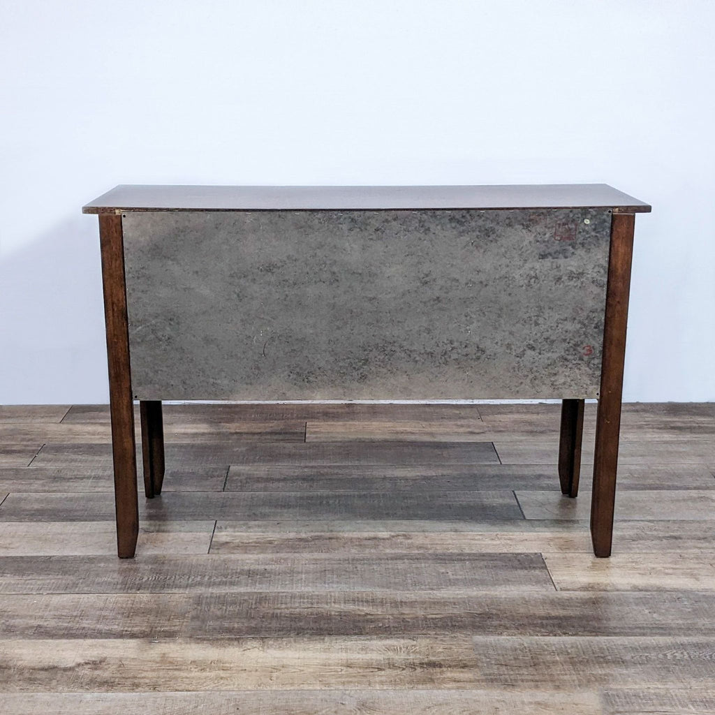 Back view of Reperch credenza, showcasing a plain metal panel and wooden legs.