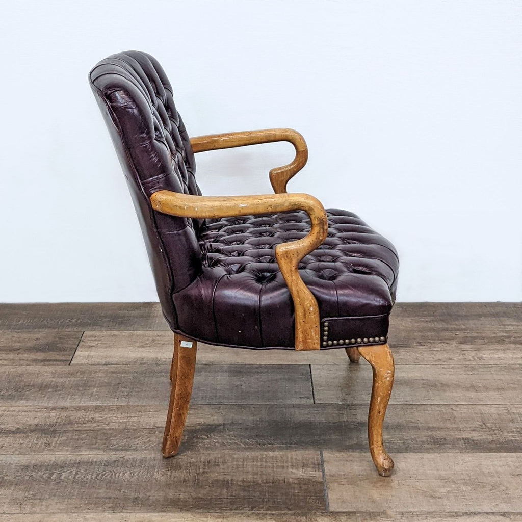 Armchair by Reperch in dark brown leather, wooden arms, and nailhead trim, suitable for a lounge.