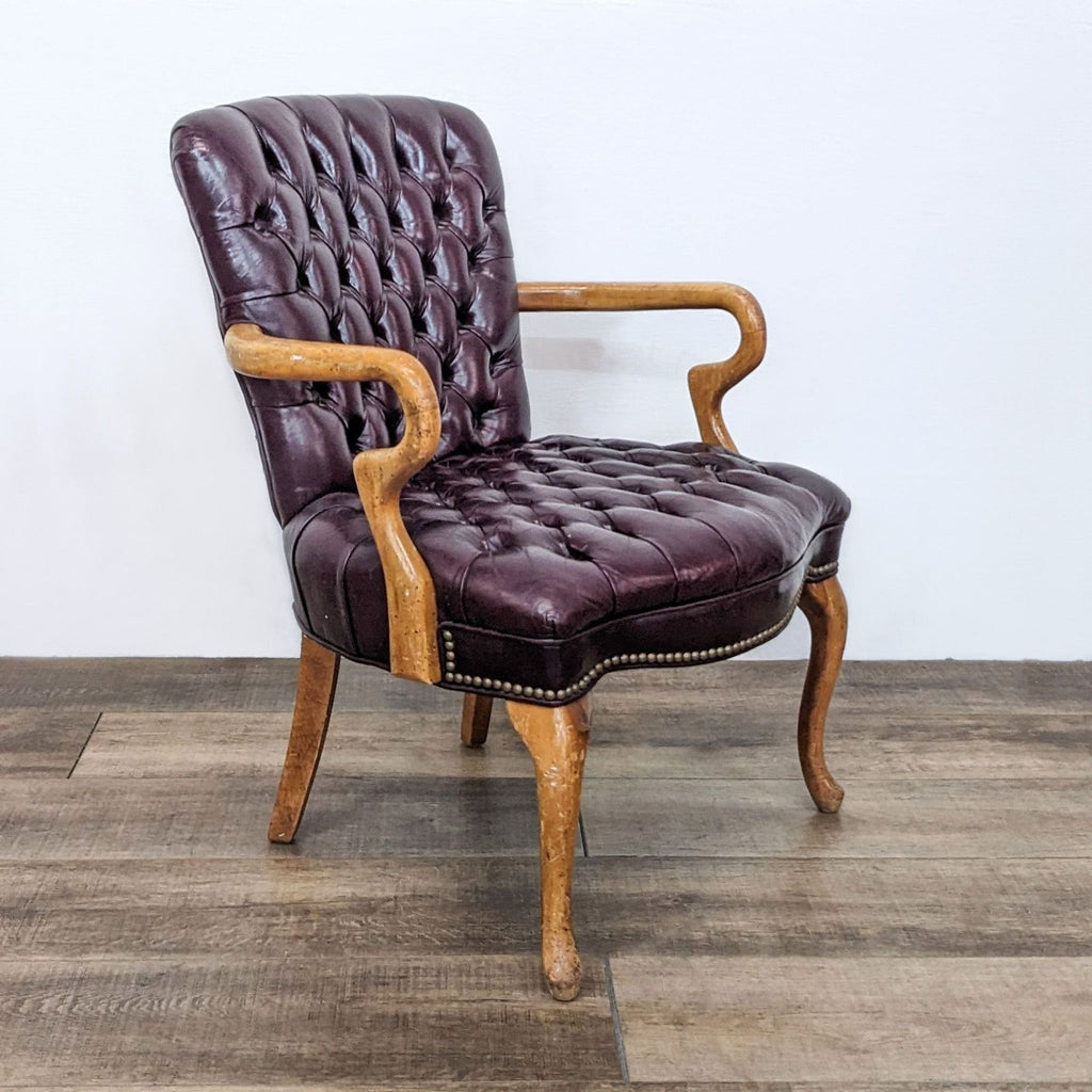 Elegant Reperch armchair, featuring dark leather upholstery with button tufts and wood accents.