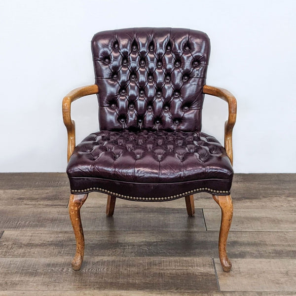 Reperch lounge chair with wood arms and dark brown leather upholstery featuring button details.