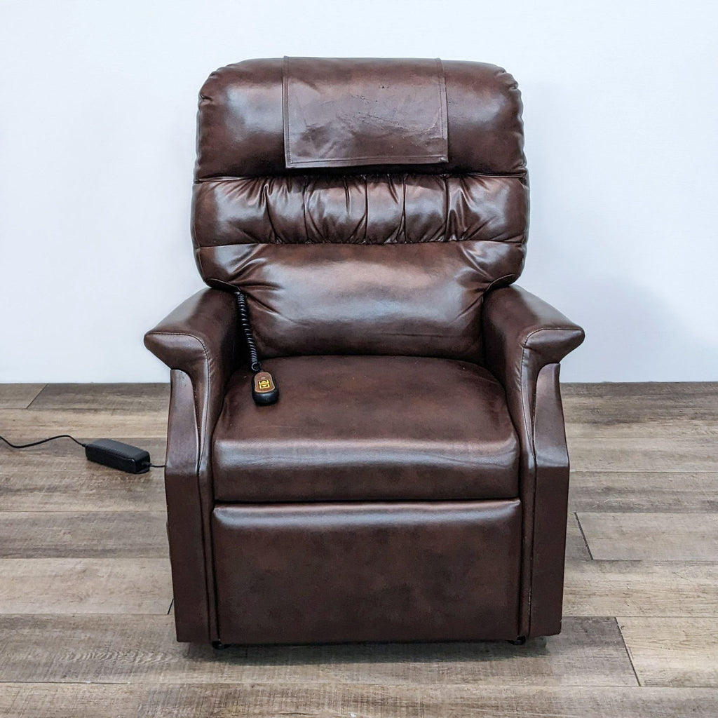 Golden Technologies PowerLift recliner in a brown leather finish, standing upright with a remote control on a wooden floor.