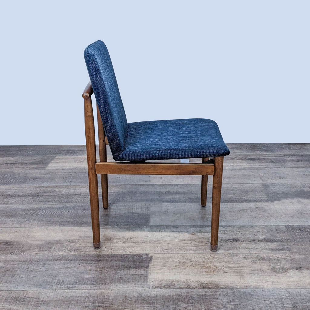 Side view of a modern West Elm dining chair with fabric cushioned seating.