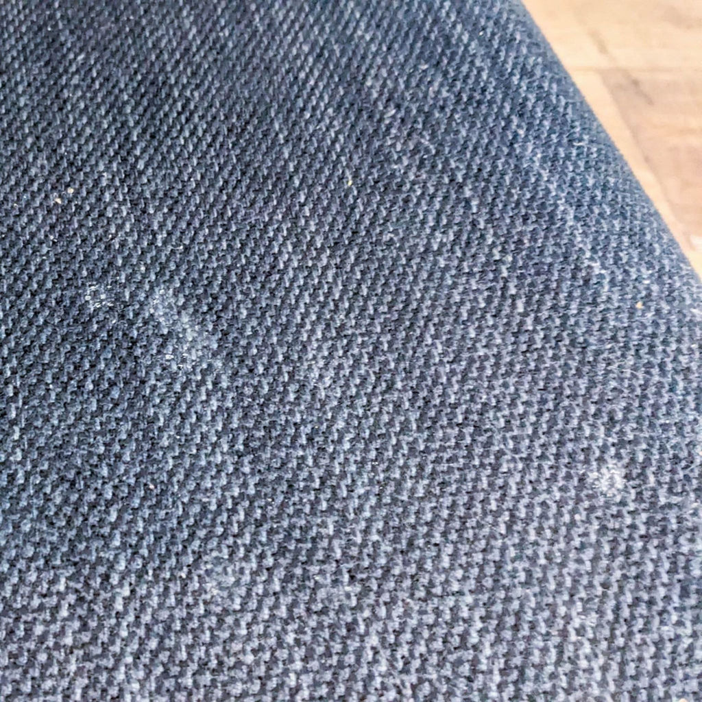 Close-up of the blue fabric upholstery on a West Elm dining chair.